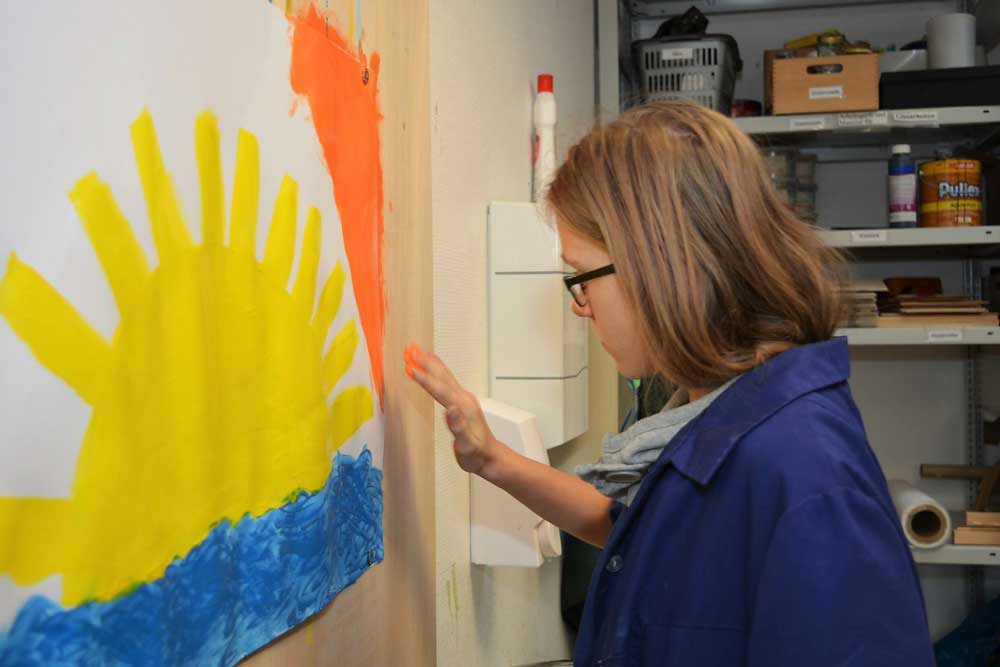 Eine Frau malt ein Bild mit Fingerfarben