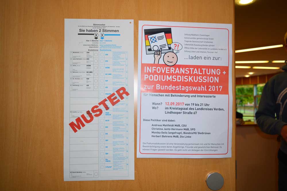 Stimmzettel für die Bundestagswahl und ein Poster für eine Infoveranstaltung zur Wahl